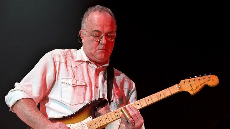 Robbie McIntosh jouant de la guitare lors d'un concert