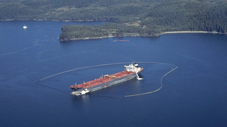 Le pétrolier Exxon Valdez entouré d’une barrière flottante