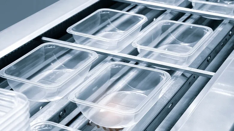 Conteneurs en plastique sur une chaîne de production