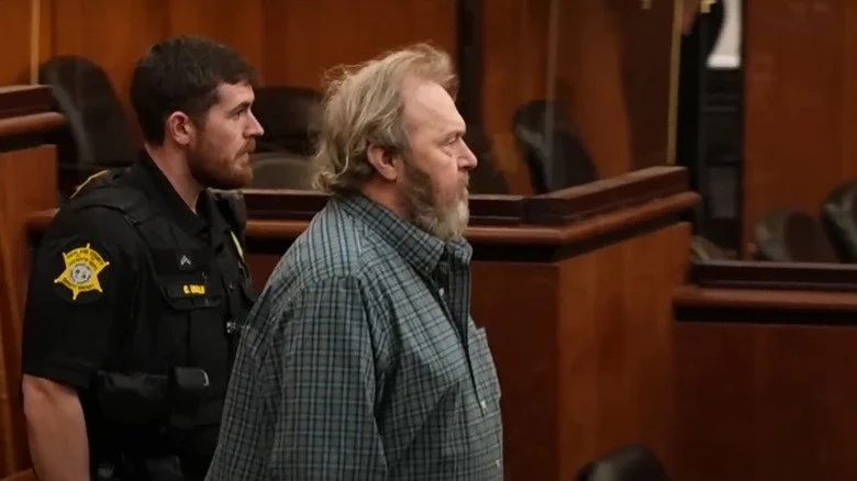 Smith entre à l'audience avec un officier de justice