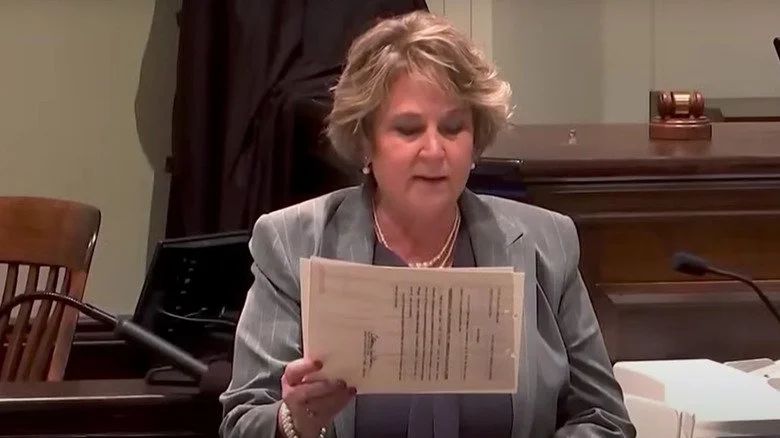Becky Hill au tribunal tenant des documents et prenant la parole