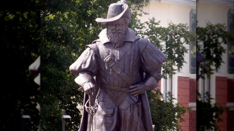 Statue de Christopher Newport portant un chapeau et tenant une épée, autre main sur la hanche