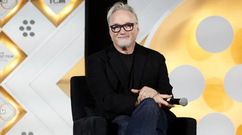 David Fincher assis sur une chaise avec un micro dans la main