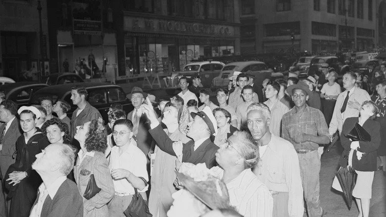 Des New-Yorkais regardant et pointant le ciel après qu'un avion ait percuté l'Empire State Building
