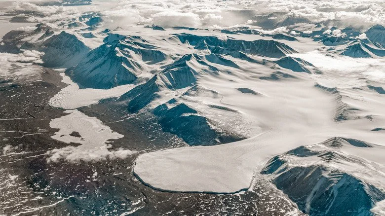 Vue aérienne des roches et de la neige dans la région désertique antarctique.
