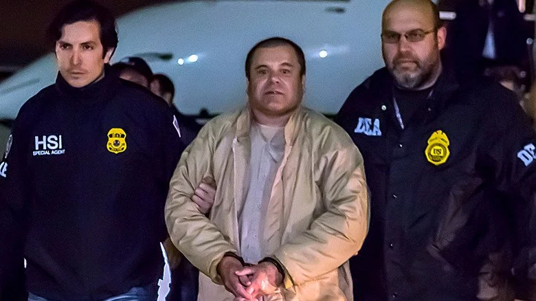 El Chapo arrêté, encadré par deux agents