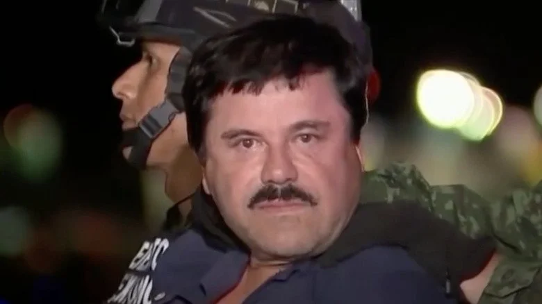 El Chapo entouré de gardes militaires regardant la caméra
