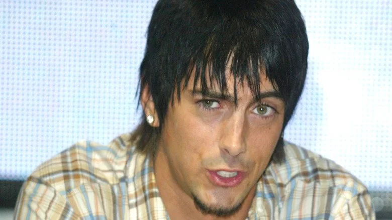 Ian Watkins en chemise à carreaux, dents serrées