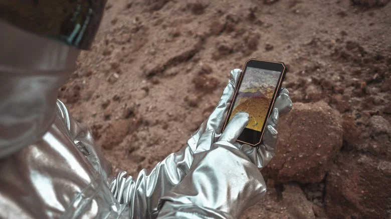 Astronaute portant un casque et utilisant un smartphone
