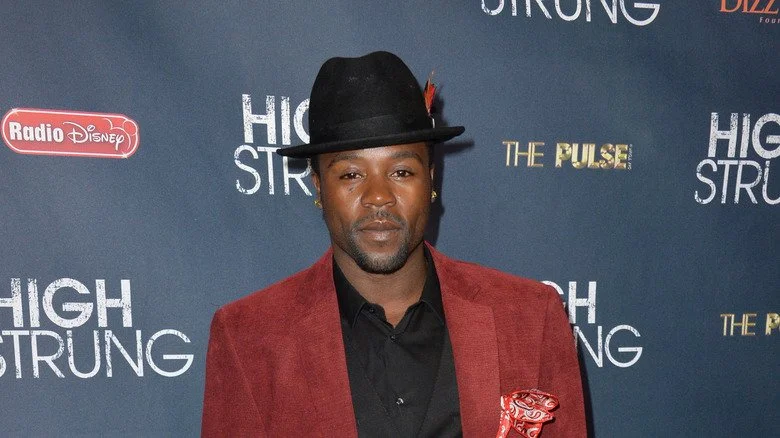 Joshua Allen sur le tapis rouge avec un chapeau à plumes
