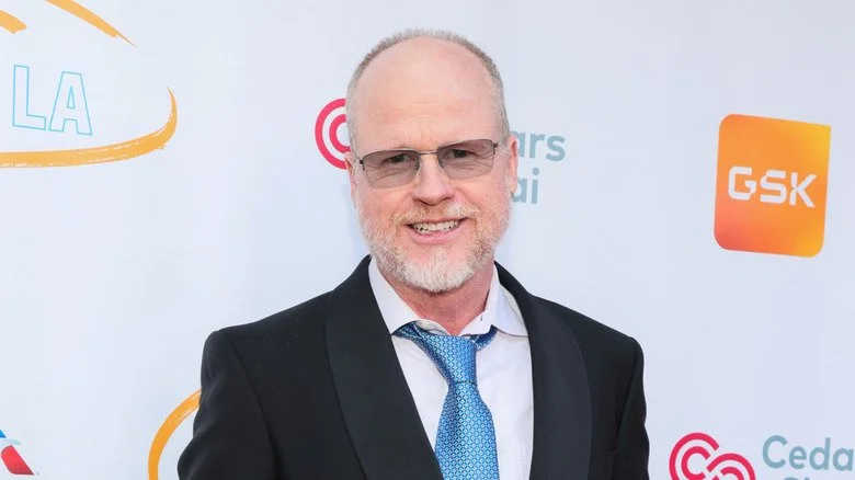 Joss Whedon souriant sur le tapis rouge en 2024