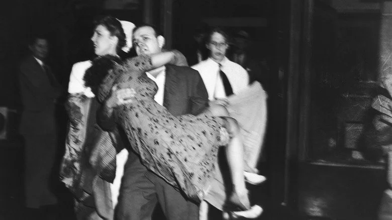 Distressed man carrying a woman out of the Empire State Building