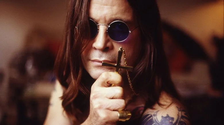 Ozzy Osbourne posant avec un pendentif en forme de croix