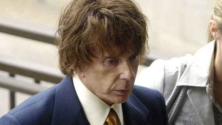 Phil Spector in blue suit and messy hair outside courthouse