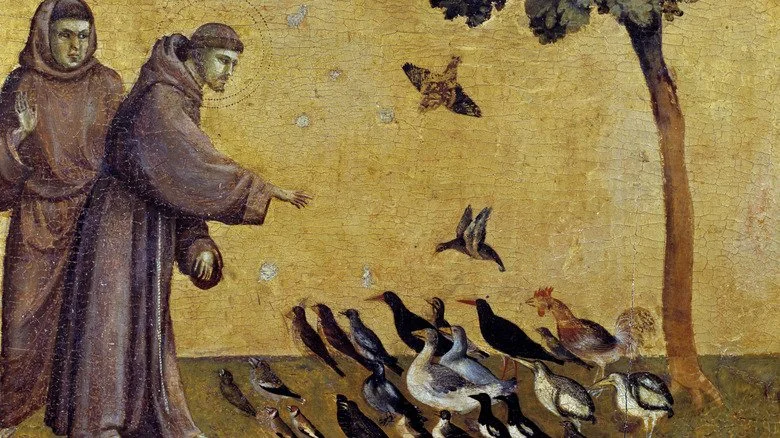 Saint François, main levée, entouré d’oiseaux