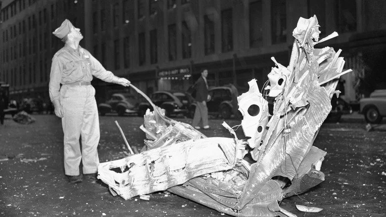 Un soldat avec des débris d'avion tombés dans la rue