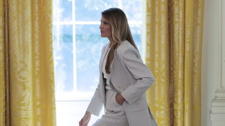Melania Trump en tailleur gris marchant dans les jardins de la Maison-Blanche
