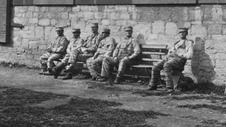 Détenus assis sur un banc devant la prison d'Auburn, New York