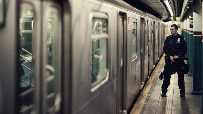Agent de police devant un wagon de métro à la station Astor Place
