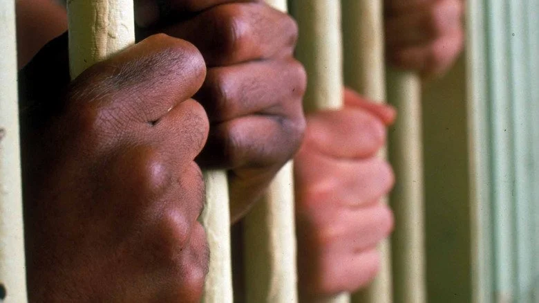 Mains agrippant les barreaux d'une cellule à la Virginia State Penitentiary