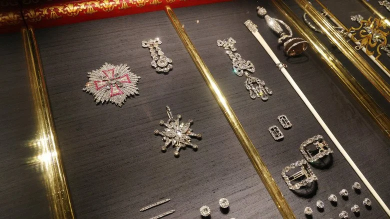 Bijoux retrouvés après le braquage vert.”/><figcaption>Sean Gallup/Getty Images</figcaption></figure>
<p>Les joyaux du Green Vault, au palais royal de Dresde, représentaient une cible fort tentante. En 2019, des voleurs pénétrèrent dans cette section sous la surveillance de gardes et de caméras. L’intervention rapide des gardes non armés permit d’alerter la police, et les braqueurs furent rapidement appréhendés; une diversion avait été créée par un incendie électrique pour faciliter leur fuite. Bien que tous les objets Baroque n’aient pas été dérobés, environ 123 millions de dollars en bijoux manquaient. Plusieurs pièces avaient une grande valeur historique, liées à l’histoire et à la culture de Saxe. Des recherches ultérieures ont permis de retrouver de nombreuses pièces en 2022 et cinq voleurs liés à un gang berlinois furent condamnés, quatre d’entre eux ayant vu leur peine réduite pour aider à récupérer certains bijoux.</p>
<h3><span class=