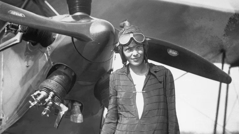 Aviatrice Amelia Earhart devant son avion