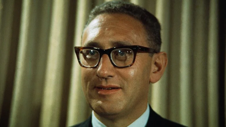 Henry Kissinger devant un rideau doré
