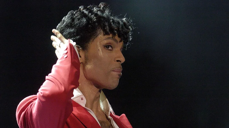 Prince sur scène, main près de l'oreille