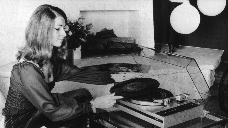 Femme écoutant un vinyle sur un tourne-disque dans les années 1970