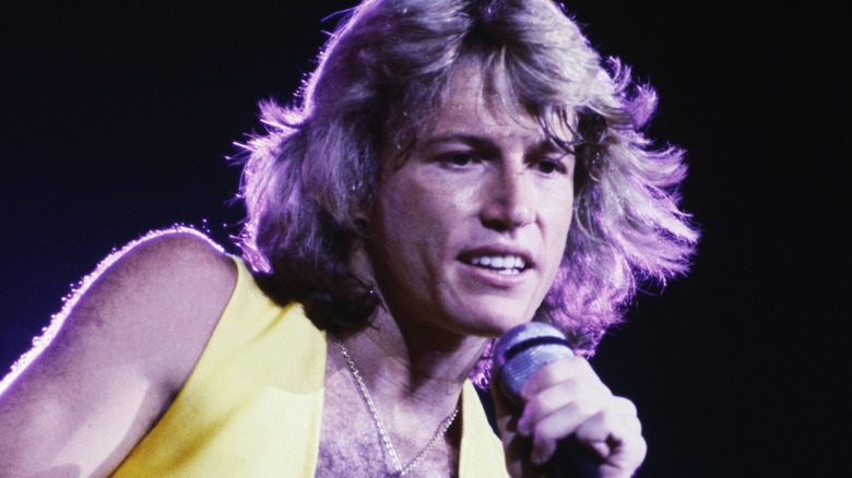 Andy Gibb chantant dans une combinaison jaune