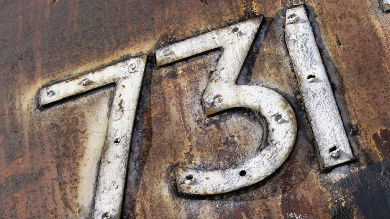 Panneau blanc avec l'inscription 731 sur du métal rouillé