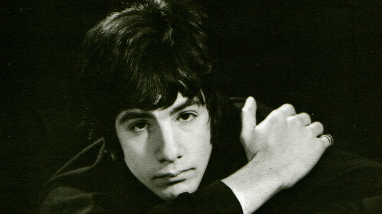 Le jeune Cat Stevens penché en avant sur un fond sombre