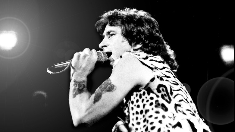 Bon Scott chantant dans un micro sur scène
