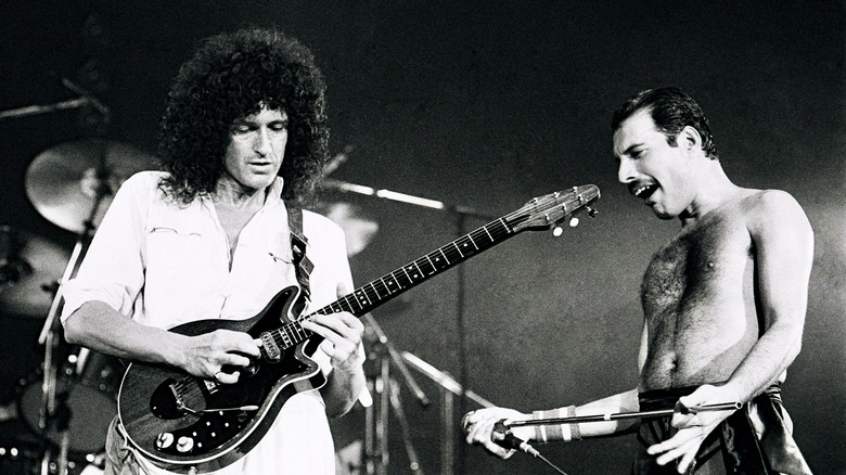 Brian May jouant un solo de guitare sous le regard de Freddie Mercury