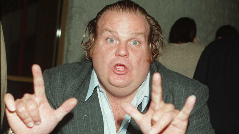 Chris Farley en costume faisant un signe des mains lors d'un événement