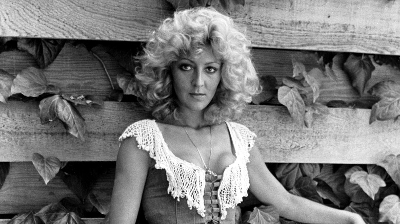 Christa Helm posant contre une clôture