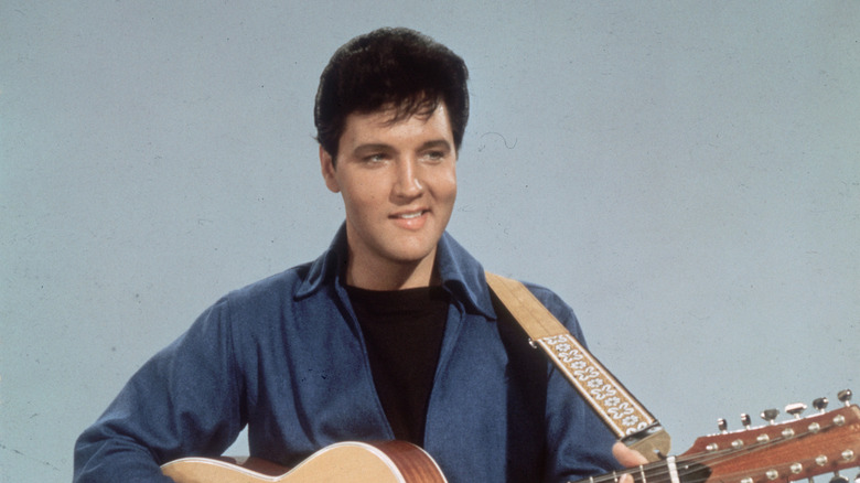 Elvis Presley souriant avec une guitare