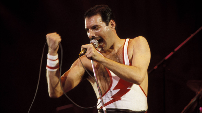 Freddie Mercury chantant dans un microphone sur scène