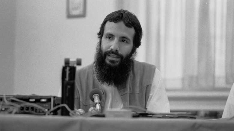 Cat Stevens avec une longue barbe parlant lors d'une conférence de presse