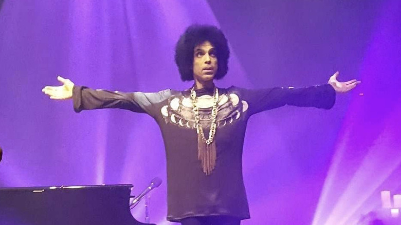Prince étendant ses bras durant un concert en 2016