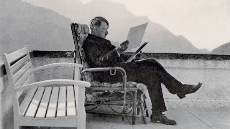 Hitler lisant des dossiers assis à l'extérieur