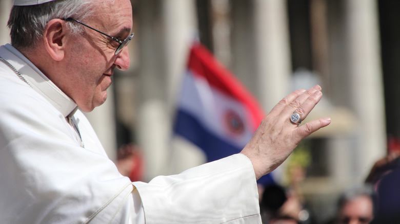 Pape François portant une bague et faisant un signe de la main