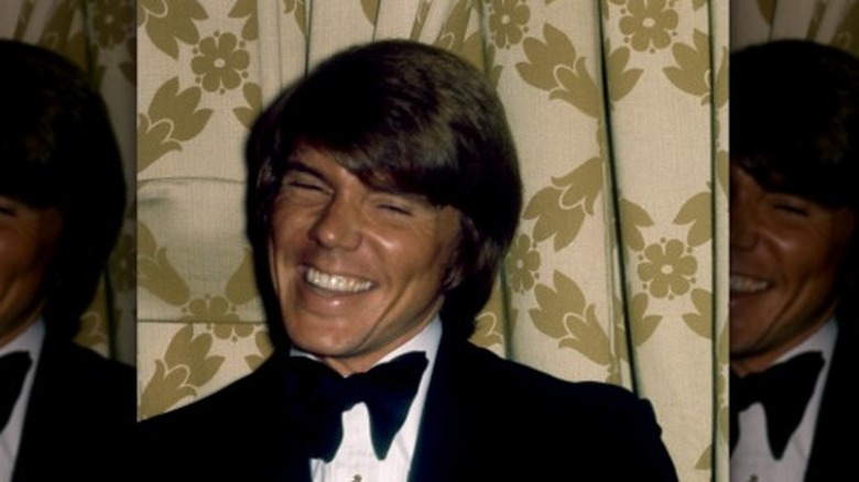 John Davidson souriant avec un nœud papillon