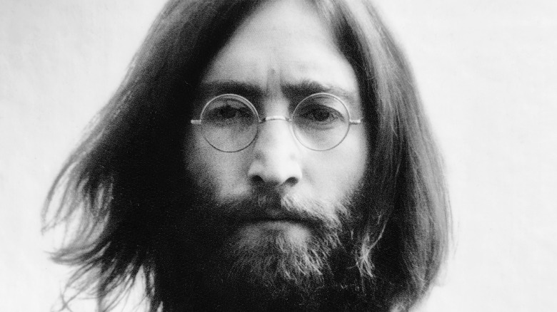 John Lennon assis à l'intérieur près d'une fenêtre