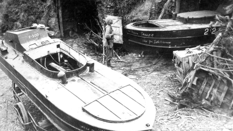 Un marine américain inspectant deux bateaux explosifs shinyo à Okinawa, 1945
