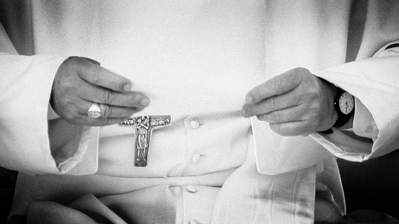 Mains du Pape François posées sur ses genoux