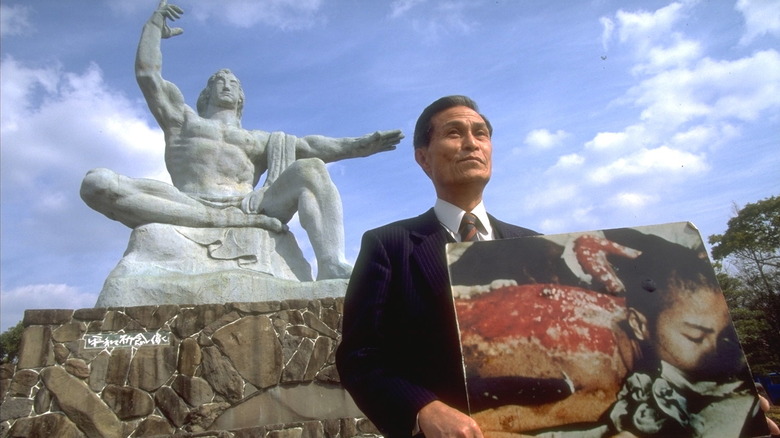 Sumiteru Taniguchi tenant une photo de lui-même avec le dos ensanglanté après Hiroshima