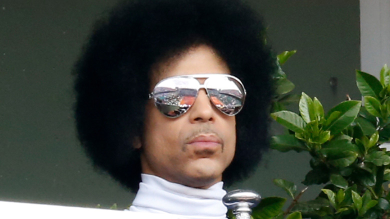 Prince avec des lunettes miroirs au regard sévère