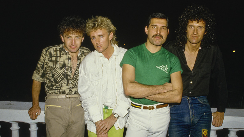 Les membres de Queen posant devant un fond noir