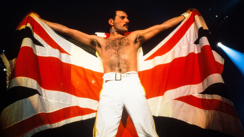 Freddie Mercury posant sur scène avec un drapeau Union Jack